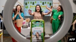 Monica Amadea (tengah), pemilik kanal Monomolly, dan karyawannya sengan menawarkan produk melalui siaran langsung (livestream) di Tiktok, Jakarta 4 April 2023. (Foto: Bay Ismoyo/AFP)