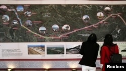 FILE - Participants look at an exhibition of a high speed rail during the groundbreaking ceremony of the cooperation between Thailand and China on the Bangkok-Nong Khai high speed rail development in Nakhon Ratchasima, Thailand, Dec. 21, 2017. 
