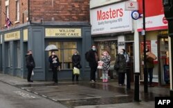 Warga antre di luar kantor pos di Whitchurch, Inggris tengah, 13 Desember 2021, (Paul ELLIS / AFP)