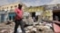FILE - Residents look at the aftermath of an al-Shabab militant attack in Mogadishu, Aug. 21, 2022. 