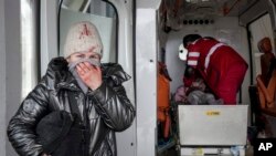 Ibu korban menangis penuh harap ketika para paramedis melakukan CPR pada gadis kecil yang terluka dalam baku tembak di Mariupol, Ukraina, pada 27 Februari 2022. Gadis kecil tersebut akhirnya tidak bisa diselamatkan. (Foto: AP/Evgeniy Maloletka)