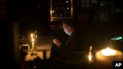 A man sits in a caffe during a blackout in Kyiv, Ukraine, Nov. 4, 2022.