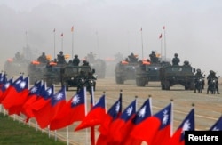 Kendaraan militer melewati bendera Taiwan selama latihan militer di Hsinchu, Taiwan tengah 27 Januari 2010. (Foto: REUTERS/Nicky Loh)
