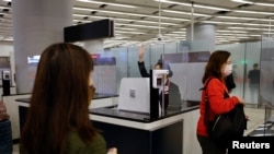 A worker checks passengers tickets at West Kowloon High-Speed Train Station Terminus on the first day of the resumption of rail service to mainland China, during the coronavirus disease (COVID-19) pandemic in Hong Kong, China, Jan. 15, 2023. 