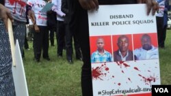 A protester holds a sign picturing human rights attorney Willie Kimani, his client Josephat Mwenda and their taxi driver Joseph Muiruri allegedly killed by police, at a rally in Nairobi, Kenya, July 4, 2016. (J. Craig/VOA)