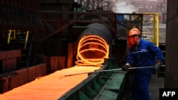 FILE - A Chinese employee sorts hot red steel at a steel plant in Zouping in China's eastern Shandong province, March 5, 2018.