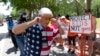 A member of the National Rifle Association plugs his ears with his fingers as he walks past protesters during the NRA's annual meeting at the George R. Brown Convention Center in Houston, May 27, 2022.