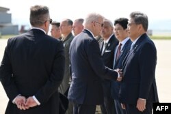 조 바이든(가운데) 미국 대통령이 22일 한국 방문을 마치고 일본으로 출발하기에 앞서 오산 공군기지에 배웅나온 박진 한국 외교부 장관과 악수하고 있다.