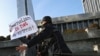 FILE - Police officers restrain a protester during a rally of journalists against a new media bill, in front of the Parliament building in Baku, Azerbaijan, Dec. 28, 2021. 