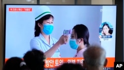 2022年5月14日，周六，在韩国首尔的一个火车站，人们正在观看有关朝鲜新冠肺炎疫情的新闻报道。