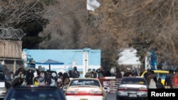 FILE - Members of the Taliban stand guard at the entrance gate of Kabul University in Kabul, Dec. 21, 2022. 