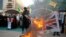 Supporters of the Iran-backed Kataib Hezbollah militia burn representations of Israeli, U.S. and British flags during a protest against the United Arab Emirates and Bahraini normalization agreement with Israel in Najaf, Iraq, Sept. 18, 2020.