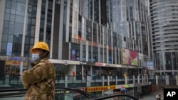 一名身穿工装的工人乘坐电梯到达北京一个空荡荡的商贸区。（2023年1月11日）