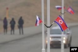 Flags of Russia and North Korea are seen fixed on lamp posts on Russky island in the far-eastern Russian port of Vladivostok on April 23, 2019.