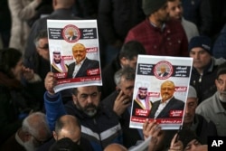 FILE - In this Nov. 16, 2018 file photo, members of Arab-Turkish Media Association and friends of Washington Post columnist Jamal Khashoggi hold posters showing images of Saudi Crown Prince Muhammed bin Salman and of Khashoggi.