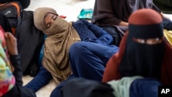 Ethnic Rohingya people rest at a temporary shelter in Bireuen, Aceh province, Indonesia, Sunday, March 6, 2022.