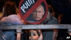 A girl holds a placard depicting Russian President Vladimir Putin at a protest against the Russia's invasion of Ukraine in Tel Aviv, Israel, March 5, 2022.