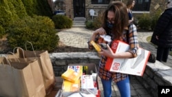 Pamela Chinchilla looks through donations before Maria and David get married at a home, March 5, 2022, in Oak Park, Ill.