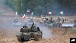 پولینڈ، اٹلی، کینیڈا اور امریکہ کی عکسری بکتربند گاڑیاں لیٹویا میں ملٹری مشقوں میں حصہ لیتے ہوئے۔ 13 ستمبر، 2021ء (فائل فوٹو)