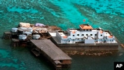 FILE - A Chinese flag flies from one of the two newly-finished concrete structures on the Mischief Reef off the disputed Spratlys group of islands in the South China Sea in this aerial photo taken on Monday, Feb. 8, 1999. (AP Photo/Aaron Favila)