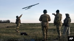FILE - Ukrainian soldiers launch a drone at Russian positions near Bakhmut, Donetsk region, Ukraine, Dec. 15, 2022. 