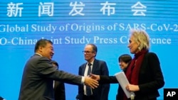 FILE: Marion Koopmans and Peter Ben Embarek of the World Health Organization team say farewell to their Chinese counterpart Liang Wannian, after a WHO-China Joint Study Press Conference at the end of the WHO mission in Wuhan, Feb 9, 2021.