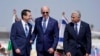 Presiden Joe Biden diapit Perdana Menteri Israel Yair Lapid (kanan) dan Presiden Isaac Herzog (kiri) setibanya di Bandara Ben Gurion, Tel Aviv, Rabu, 13 Juli 2022. (AP/Evan Vucci)