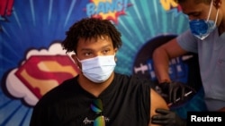 ARHIVA - Mladi Amerikanac prima buster vakcinu farmaceutskih kompanija Fajzer i Bajontek 