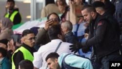 A protester against the Iranian regime is led away by security personel at the friendly football match between Iran and Uruguay in Sankt Poelten, Austria, Sept. 23, 2022, following the death of Iranian woman Mahsa Amini.