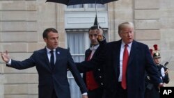 美国总统特朗普在抵达巴黎爱丽舍宫时受到法国总统马克龙的欢迎。（2018年11月10日）