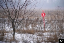 Signs warn of minefields close to the line that separates the areas controlled by the Ukrainian military from those controlled by pro-Russian separatists, in Avdiivka, Donetsk region, eastern Ukraine, Feb. 3, 2022.