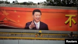 路人从习近平的宣传看板前骑车驶过。