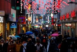 Pembeli berjalan menyusuri distrik perbelanjaan Hohe Strasse satu hari menjelang diberlakukannya lockdown total akibat meningkatnya kasus terkonfirmasi Covid-19 di Cologne, Jerman, 15 Desember 2020.