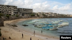 In this file photo, people stand and walk on a beach in the old port of Mogadishu, Somalia, Nov. 13, 2013. In a report released Wednesday, global watchdog Transparency International ranked Somalia last in the world for corruption problems.