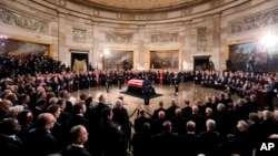 The flag-draped casket of former President George H.W. Bush lies in state in the Capitol Rotunda in Washington, Monday, Dec. 3, 2018. (Jonathan Ernst/Pool via AP)