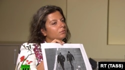 RT Editor-in-Chief Margarita Simonyan shows an image of two men during an interview with the two who are suspected by British authorities of poisoning Sergei and Yulia Skripal in Salisbury, England on March 4, 2018. 