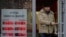 FILE - A man leaves a bank displaying currency exchange rates in Moscow, Dec. 20, 2024. 