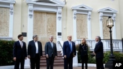 FILE - President Donald Trump stands outside St. John's Church, June 1, 2020, in Washington. Standing with Trump are Mark Esper, from left, William Barr, Robert O'Brien, Kayleigh McEnany and Mark Meadows.