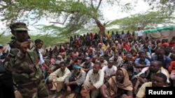 FILE - Members of the militant group al-Shabab listen to a Somalia government soldier after their surrender to the authorities in Mogadishu, Sept. 24, 2012.