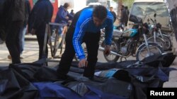 A man attempts to identify bodies after what activists said were airstrikes carried out by the Russian air force in Idlib city, Syria, Dec. 20, 2015.