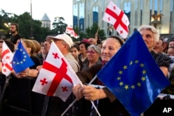 FILE - Demonstrators gather with Georgian national and EU flags in front of the parliament building in Tbilisi, Georgia, July 3, 2022.
