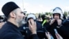 Montenegro, Podgorica, A Serbian Orthodox Church priest speaks with a riot policeman on a bridge near the parliament