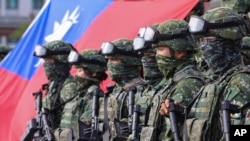 FILE - Soldiers pose with a Taiwan flag on Jan. 11, 2023. Taiwan says 103 Chinese warplanes flew toward the island in new daily high in recent times. Taiwan's Defense Ministry said that it detected the planes in the 24 hours ending at 6 a.m. Monday, Sept. 18, 2023. 