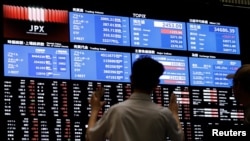 Media members observe the stock quotation board at the Tokyo Stock Exchange in Tokyo, Japan, Aug. 6, 2024.