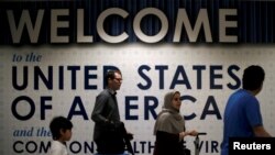 FILE - International passengers arrive at Washington Dulles International Airport, in Dulles, Virginia, June 26, 2017.