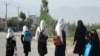 FILE - Afghan girls walk to their school along a road in Gardez, Paktia province, on Sept. 8, 2022. Before the Taliban’s takeover of Afghanistan, about 3.5 million girls out of roughly 9 million students were going to school.