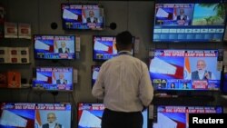Prodavac gleda obraćanje premijera Narendre Modija nadiciji, preko TV ekrana u prodavnici u Mumbajiju, Indija, 27. marta 2019.