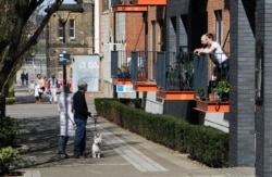 People converse at a distance in Woolwich as the spread of the coronavirus disease continues, in London, April 4, 2020.