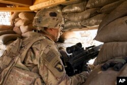 FILE - A U.S. Army soldier guards a position at Camp Swift, northern Iraq, Sept. 8, 2016.