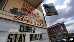 FILE - A sign announces a coronavirus closure at a restaurant in Livermore Falls, Maine, April 16, 2020. 